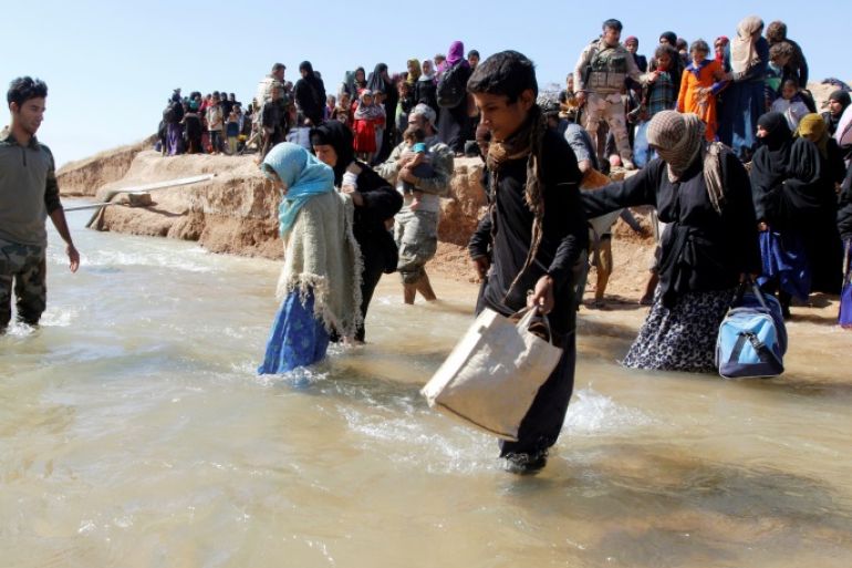 Displaced people, who fled from their homes in Hawija, cross the water to reach the other bank to be transported to camps for displaced people, in southwest of Kirkuk, Iraq October 4, 2017. REUTERS/Ako Rasheed