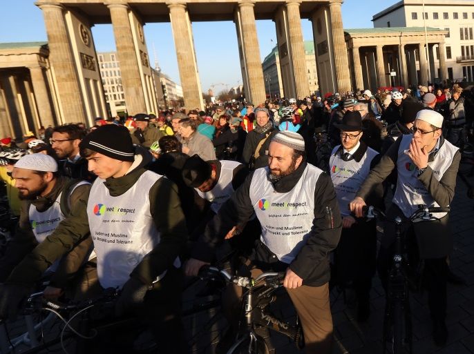 BERLIN, GERMANY - MARCH 22: Participants prepare to depart from the Brandenburg Gate at the beginning of a 'unity rally' of imams and rabbis riding through the city together on tandem bicycles on March 22, 2015 in Berlin, Germany. Organizers of the event hope that the mass demonstration calling for 'tolerance' will counteract what is seen as a decline in the relationship between Muslims and Jews in the country, one bearing a history of government-sanctioned antisemitism that now has to reconcile both attacks against Jews for wearing yarmulkes as well as issues stemming from integrating a large Arab and Turkish minority, against the backdrop of ongoing religious and territorial conflict in the Middle East and consequences of it elsewhere in Europe. (Photo by Adam Berry/Getty Images)