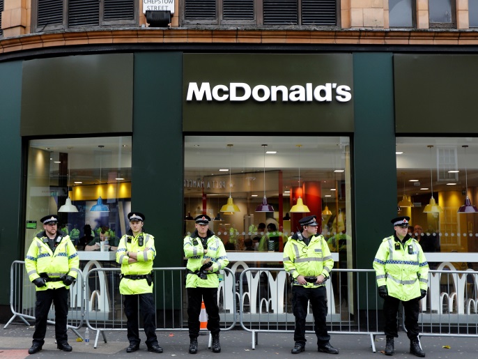 Police officers stand guard outside a McDonald's restaurant during protests on the opening day of the Conservative Party conference in Manchester, Britain on October 1, 2017.  Reuters/Darren Staples