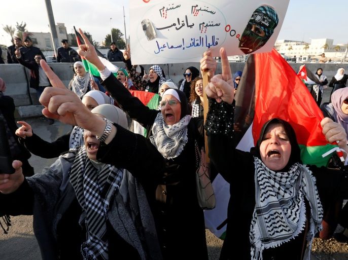 Protesters shout slogans during a protest near the U.S. Embassy in Amman, Jordan December 13, 2017. The placard reads,