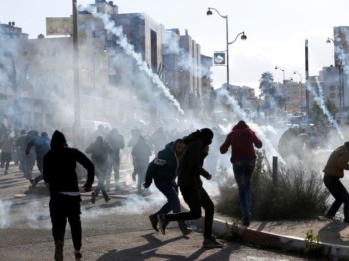 Palestinian protesters run from tear gas fired by Israeli troops during clashes at a protest against U.S. President Donald Trump's decision to recognize Jerusalem as the capital of Israel, near the Jewish settlement of Beit El, near the West Bank city of Ramallah December 7, 2017. REUTERS/Mohamad Torokman