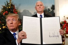 U.S. Vice President Mike Pence stands behind as U.S. President Donald Trump holds up the proclamation he signed that the United States recognizes Jerusalem as the capital of Israel and will move its embassy there, during an address from the White House in Washington, U.S., December 6, 2017. REUTERS/Kevin Lamarque TPX IMAGES OF THE DAY