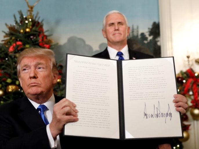 U.S. Vice President Mike Pence stands behind as U.S. President Donald Trump holds up the proclamation he signed that the United States recognizes Jerusalem as the capital of Israel and will move its embassy there, during an address from the White House in Washington, U.S., December 6, 2017. REUTERS/Kevin Lamarque TPX IMAGES OF THE DAY