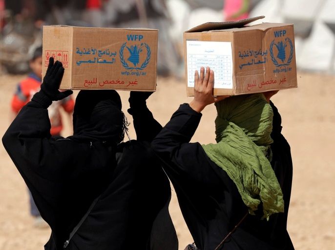 People displaced from fightings between the Syrian Democratic Forces and Islamic State militants carry boxes of food aid given by UN's World Food Programme at a refugee camp in Ain Issa, Syria October 10, 2017. REUTERS/Erik De Castro