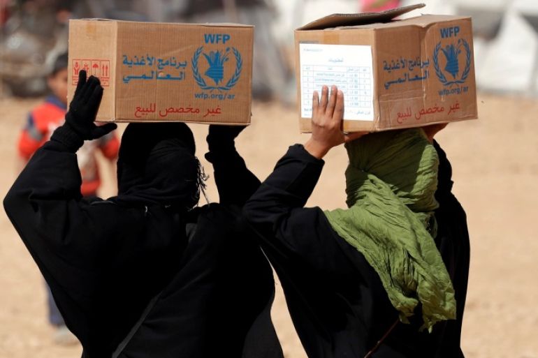 People displaced from fightings between the Syrian Democratic Forces and Islamic State militants carry boxes of food aid given by UN's World Food Programme at a refugee camp in Ain Issa, Syria October 10, 2017. REUTERS/Erik De Castro