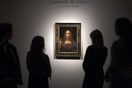LONDON, ENGLAND - OCTOBER 24: Staff members pose next to a painting by Leonardo da Vinci entitled 'Salvator Mundi' before it is auctioned in New York on November 15, at Christies on October 24, 2017 in London, England. The painting is the last Da Vinci in private hands and is expected to fetch around 100,000,000 USD. (Photo by Carl Court/Getty Images)