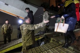 Ukrainian President Petro Poroshenko helps a woman to get off a plane during a ceremony to welcome prisoners of war (POWs), released after the exchange with pro-Russian separatists, at Boryspil International Airport outside Kiev, Ukraine December 28, 2017. Mikhail Palinchak/Ukrainian Presidential Press Service/Handout via REUTERS ATTENTION EDITORS - THIS IMAGE WAS PROVIDED BY A THIRD PARTY.