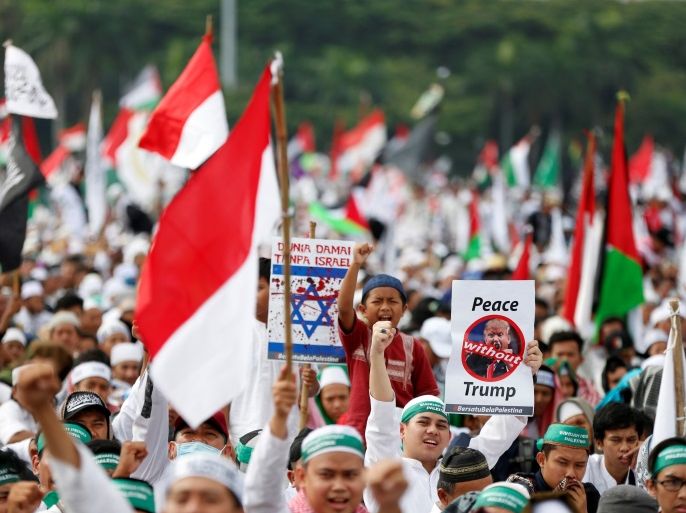 Protesters hold signs during a rally to condemn U.S. President Donald Trumps's decision to recognise Jerusalem as Israel's capital, at Monas, the national monument, in Jakarta, Indonesia, December 17, 2017. REUTERS/Darren Whiteside