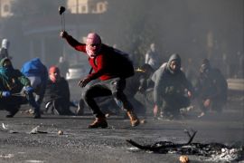 A Palestinian protester uses a sling to hurl stones towards Israeli troops during clashes as Palestinians call for a