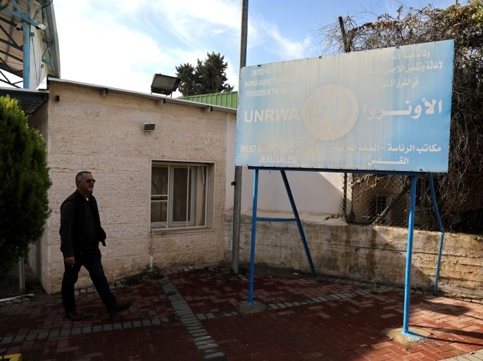 A man walks next to a sign at the entrance to the U.N. Relief and Works Agency (UNRWA) West Bank Field Office complex in East Jerusalem January 3, 2018. REUTERS/Ammar Awad