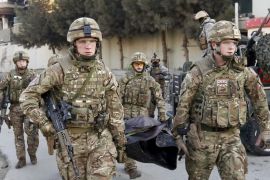 British soldiers carry the dead body of a victim after an attack on a guest house near the Spanish embassy in Kabul, Afghanistan December 12, 2015. Afghan security forces suppressed a suicide attack on a guest house attached to the Spanish embassy in Kabul, killing three Taliban fighters after hours of intermittent gunfire and explosions that lasted into the early hours of Saturday. REUTERS/Mohammad Ismail