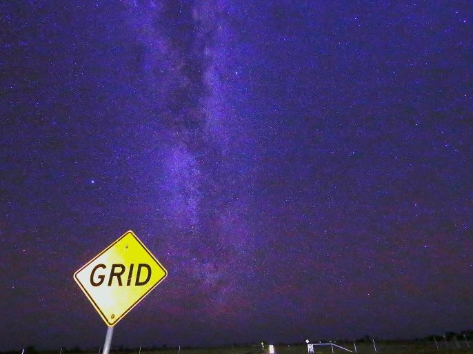A cattle-grid sign stands on the road with the Milky Way and stars in the background, on the outskirts of Stonehenge in Queensland, Australia, August 12, 2017. REUTERS/David Gray SEARCH