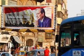 People walk near a poster of Egyptian President Abdel Fattah al-Sisi of the campaign titled, “Alashan Tabneeha” (So You Can Build It), that demands al-Sisi to run in the next year's presidential election, at Sayeda Zainab square in downtown of Cairo, Egypt October 17, 2017. Picture taken October 17, 2017. REUTERS/Amr Abdallah Dalsh