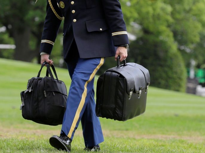 A White House military aide and member of the U.S. Army carries the brief case containing nuclear weapons codes as U.S. President Barack Obama returns to the White House in Washington, U.S., May 15, 2016. REUTERS/Joshua Roberts