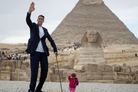 epa06475989 World's tallest man, Sultan Kosen of Turkey and shortest woman, Jyoti Amge of India, pose for a photo in front of the Pyramids, in Giza, Egypt, 26 January 2018. Kosen, 243 cm, and Amge 62.8 cm, both Guinness World Records holders, are visiting Egypt in an aim to promote tourism to the country. EPA-EFE/MOHAMED HOSSAM