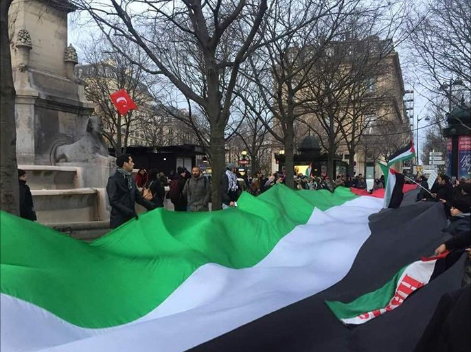 محتجون برفعون علما فلسطينيا ضخما في مظاهرة باريس رافضة لقرار ترامب حول القدس