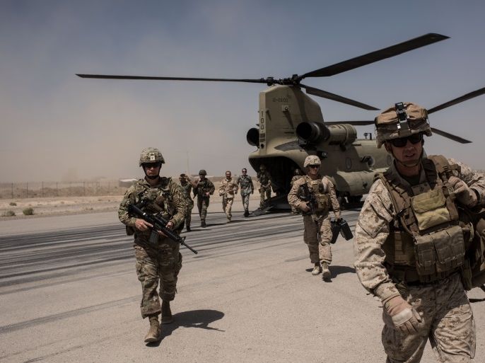 CAMP BOST, AFGHANISTAN - SEPTEMBER 11: U.S. service members walk off a helicopter on the runway at Camp Bost on September 11, 2017 in Helmand Province, Afghanistan. About 300 marines are currently deployed in Helmand Province in a train, advise, and assist role supporting local Afghan security forces. Currently the United States has about 11,000 troops in the deployed in Afghanistan, with a reported 4,000 more expected to arrive in the coming weeks. Last month, Presiden