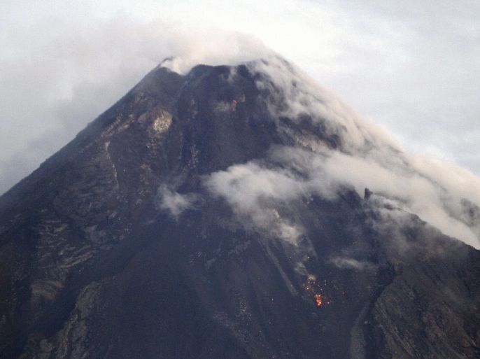Mayon Volcano is seen emitting smoke in Albay province, Bicol region, south of Manila September 17, 2014. The Philippines has evacuated more than 12,000 people from around the foot of its most active volcano as the crater glows red and authorities warn of a possible eruption. Mount Mayon, known for its near-perfect cone shape in the coconut-growing central Bicol region, has recorded a series of recent quakes and rockfalls, indicating a possible eruption within weeks.