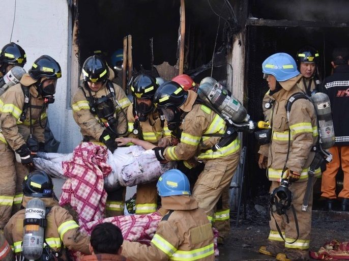 epa06474613 A handout photo made available by Kyongnamdomin Ilbo shows South Korean firefighters carrying a victim after a fire at a hospital in Miryang, South Korea, 26 January 2018. According to reports, at least 41 people were killed and more than 70 injured in the hospital fire as death toll is feared to rise. EPA-EFE/KIM GU-YEON/KYONGNAMDOMIN ILBO HANDOUT HANDOUT EDITORIAL USE ONLY/NO SALES