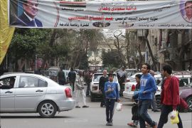 epa06470702 Egyptians walk underneath an election campaign poster erected by supporters of Egyptian President Abdel Fattah al-Sisi, in Cairo, Egypt, 24 January 2018. Egypt will hold the Presidential elections on the period between 16 to 18 March and 26 to 28 March for Egyptian abroad and locally respectively EPA-EFE/KHALED ELFIQI