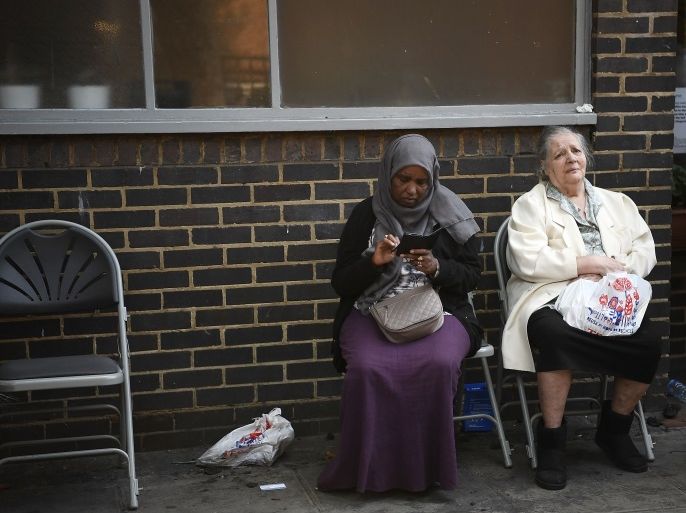 LONDON, ENGLAND - JUNE 14: Two elderly women sit together outside a community centre near the burning 24 storey residential Grenfell Tower block in Latimer Road, West London on June 14, 2017 in London, England. The Mayor of London, Sadiq Khan, has declared the fire a major incident as more than 200 firefighters are still tackling the blaze while at least 50 people are receiving hospital treatment. (Photo by Carl Court/Getty Images)