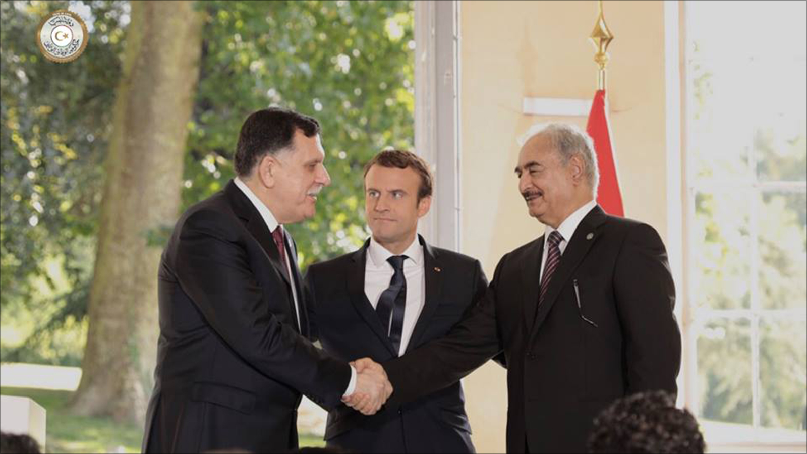‪فائز السراج (يسار) وخليفة حفتر وبينهما الرئيس الفرنسي إيمانويل ماكرون خلال لقاء بباريس في يوليو/تموز 2017‬ (الجزيرة)