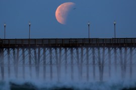 A Blue Moon comes out of a lunar eclipse as it sets past an ocean pier in Oceanside, California, U.S., January 31, 2018. REUTERS/Mike Blake TPX IMAGES OF THE DAY