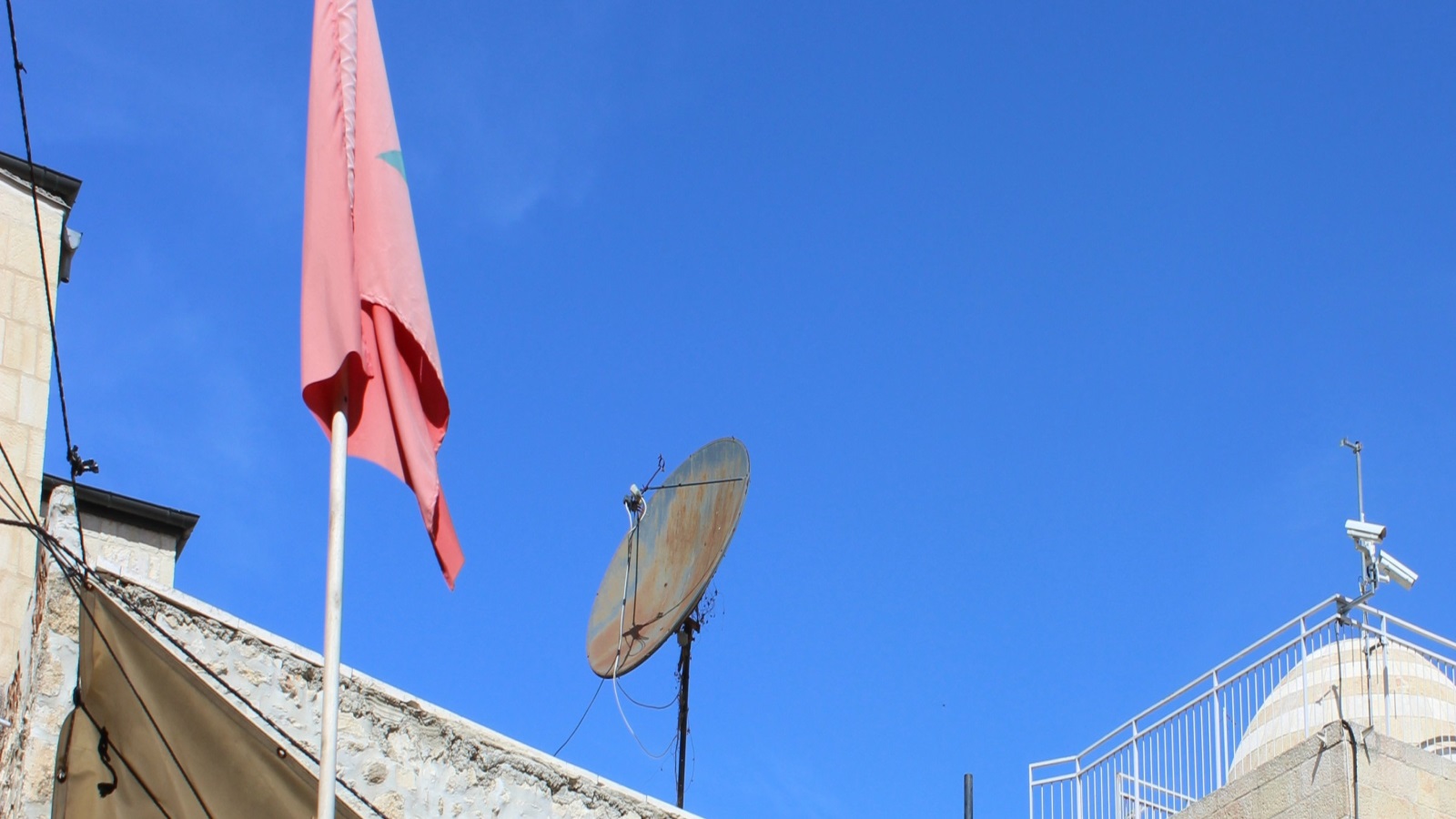 علم المغرب مرفوع أمام أحد المنازل في سماء مدينة القدس (الجزيرة)