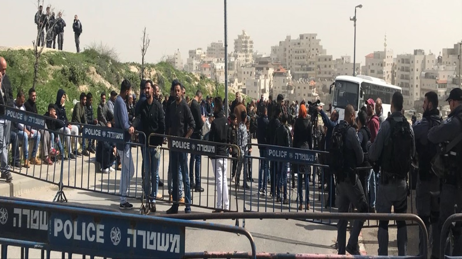 مئات الفلسطينيين يقيمون صلاة الجمعة على مدخل بلدة العيسوية شمال شرق القدس المحتلة (الجزيرة)