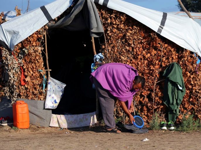 A refugee cleans his tent in a makeshift camp on the Hungary-Serbia border, on the Serbian side of a transit zone set up by Hungarian authorities to filter refugees at Roszke, Hungary, September 2, 2016. Picture taken September 2, 2016. To match Analysis EUROPE-MIGRANTS/HUNGARY-REFERENDUM REUTERS/Laszlo Balogh