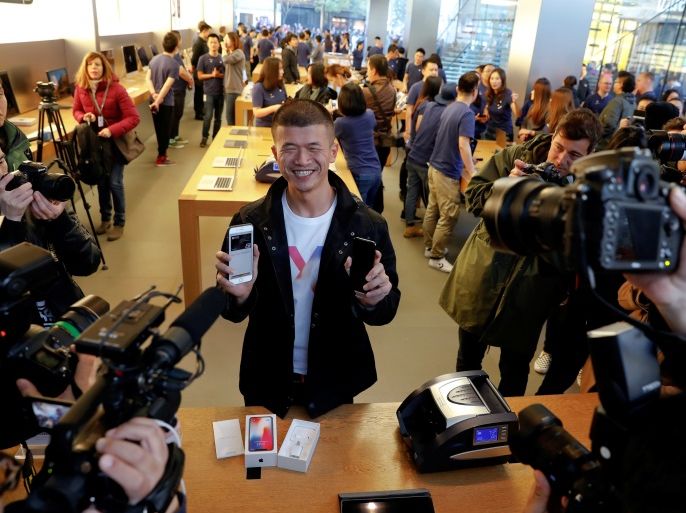 The first customer shows his new iPhone X after buying it at an Apple Store in Beijing, China November 3, 2017. REUTERS/Damir Sagolj TPX IMAGES OF THE DAY