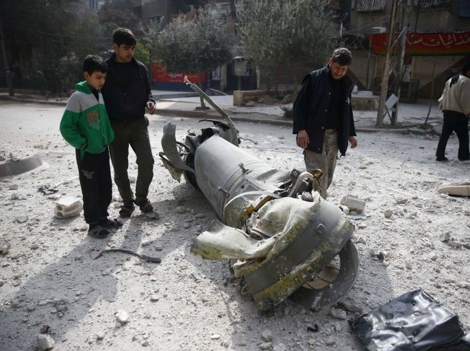 People inspect missile remains in the besieged town of Douma, in eastern Ghouta, in Damascus, Syria, February 23, 2018. REUTERS/Bassam Khabieh TPX IMAGES OF THE DAY