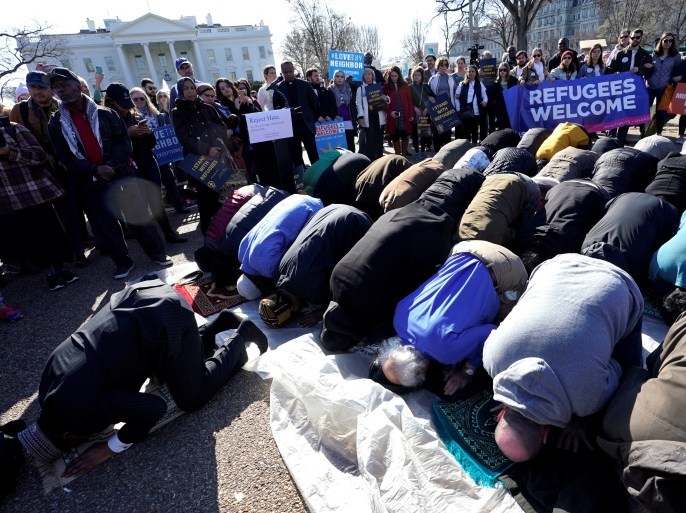 Activists pray during a rally in front of the White House, to mark the anniversary of