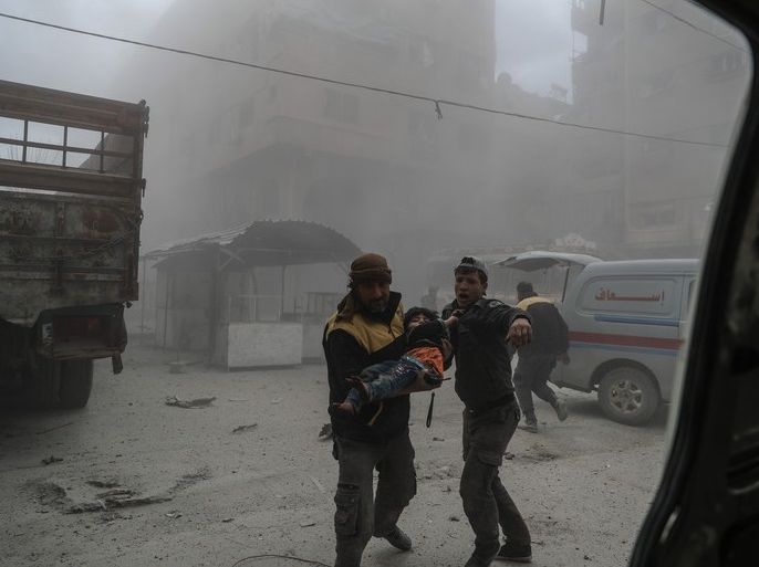 epa06555678 White helmet volunteer carries an injured boy to an ambulance after bombing, in the rebel-held Douma, Eastern Ghouta, Syria, 22 February 2018. More than 42 people got killed in Douma after several airstrikes and shelling by forces allegedly loyal to the Syrian Government. At least 80 people got killed in Eastern Ghouta on the same day, according to local sources. EPA-EFE/MOHAMMED BADRA