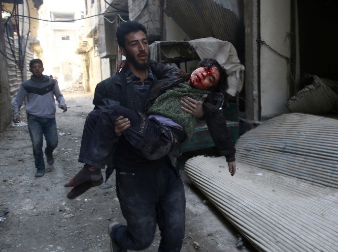 ATTENTION EDITORS - VISUAL COVERAGE OF SCENES OF INJURY OR DEATH A man carries an injured boy in the rebel held besieged town of Hamouriyeh, eastern Ghouta, near Damascus, Syria, February 21, 2018. REUTERS/Bassam Khabieh TEMPLATE OUT