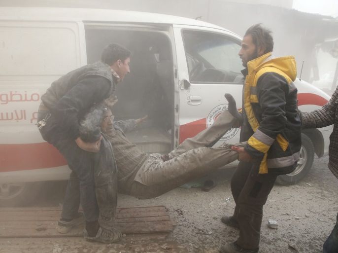 A Civil defence member carries an injured man amid dust after an airstrike in the besieged town of Douma in Eastern Ghouta in Damascus, Syria, February 7, 2018. REUTERS/Bassam Khabieh