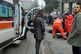 epa06493402 Paramedics treat an injured person that was shot from a passing vehicle in Macerata, Italy, 03 February 2018. According to the local authorities, the town at the eastern Italian coast near Ancona is under a lockdown due to shots being fired from a car that is driving around in the town for yet unknown reasons. EPA-EFE/GUIDO PICCHIO