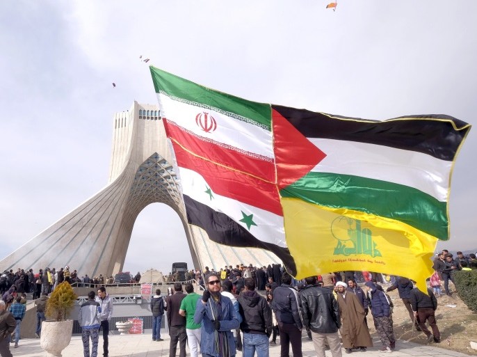 A man carries a giant flag made of flags of Iran, Palestine, Syria and Hezbollah, during a ceremony marking the 37th anniversary of the Islamic Revolution, in Tehran February 11, 2016. REUTERS/Raheb Homavandi/TIMA ATTENTION EDITORS - THIS IMAGE WAS PROVIDED BY A THIRD PARTY. FOR EDITORIAL USE ONLY.