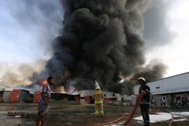 رجال إطفاء يحاولون السيطرة على حريق في ميناء الحديدة اليمني يوم السبت رويترز.