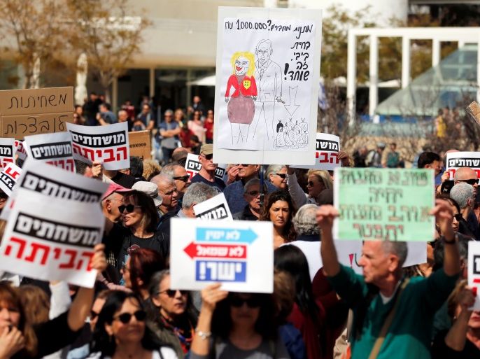 Protesters hold signs calling upon Israeli Prime Minister Benjamin Netanyahu to step down during a rally in Tel Aviv, Israel, February 16, 2018. The sign in Hebrew reads,
