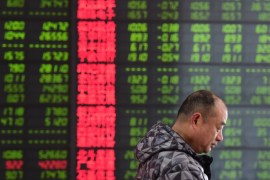 A man is seen against an electronic board showing stock information at a brokerage house in Fuyang, Anhui province, China March 23, 2018. China Daily via REUTERS ATTENTION EDITORS - THIS IMAGE WAS PROVIDED BY A THIRD PARTY. CHINA OUT.