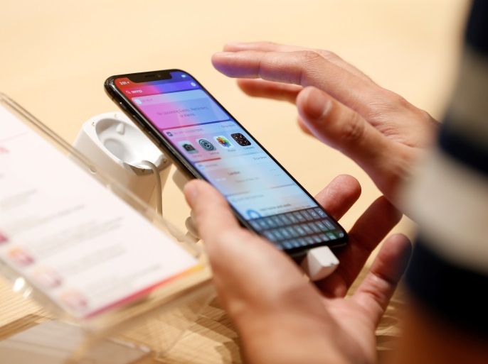 A customer tests the features of the newly launched iPhone X at VIVA telecommunication store in Manama, Bahrain, November 3, 2017. REUTERS/Hamad I Mohammed