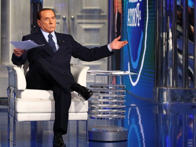 Italy's former Prime Minister Silvio Berlusconi gestures as he attends the taping of the television talk show