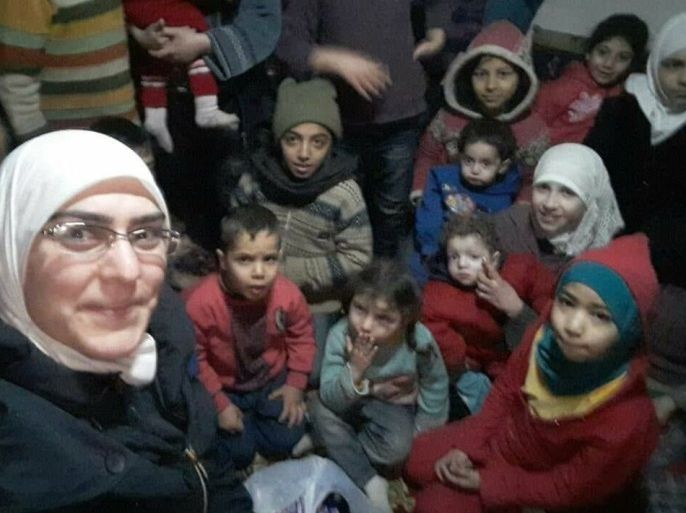 الناشطة بيان ريحان مع مجموعة من الأطفال في أحد الأقبية في الغوطة الشرقية
