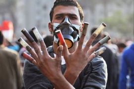 أحد المتظاهرين المصريين يضع عبوات الخراطيش في أصابعه في دلالة تحدي لقوات الأمن