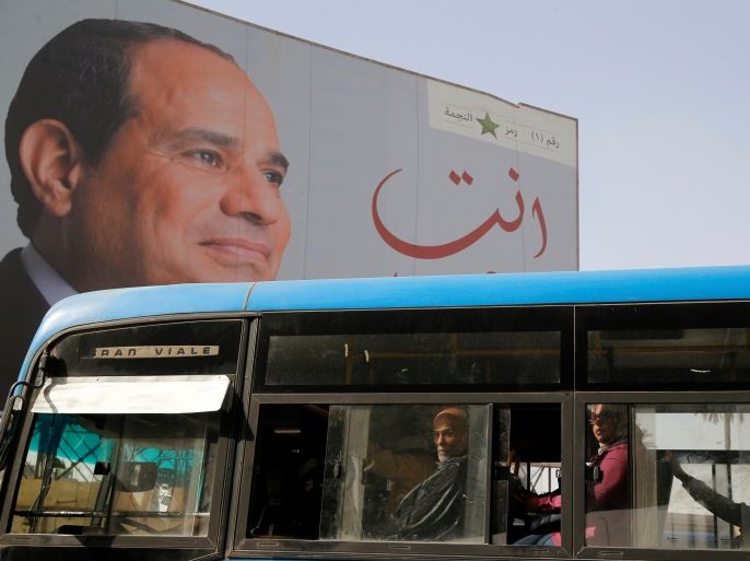 People ride on a bus as posters with Egypt's President Abdel Fattah al-Sisi are displayed during preparations for the presidential election in Cairo, Egypt March 25, 2018. REUTERS/Ammar Awad