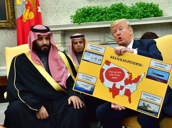 US President Donald J. Trump (R) holds up a chart of military hardware sales as he meets with Crown Prince Mohammed bin Salman