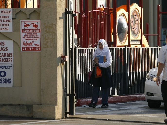 An unidentified student (L) is seen walking to class outside the Islamic Education Center, a grade school and mosque, in Houston, Texas,