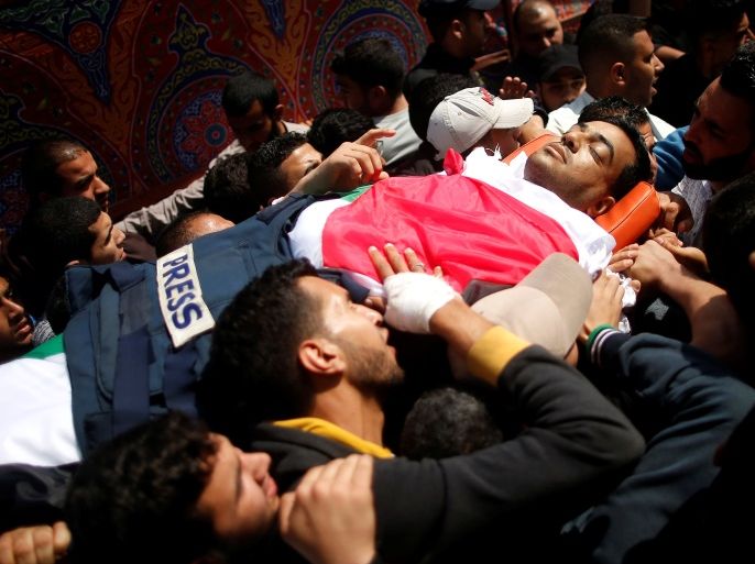 ATTENTION EDITORS - VISUAL COVERAGE OF SCENES OF INJURY OR DEATH Colleagues of Palestinian journalist Yasser Murtaja, 31, who died of his wounds during clashes at the Israel-Gaza border on Friday, carry his body during his funeral in Gaza city April 7, 2018. REUTERS/Suhaib Salem TEMPLATE OUT