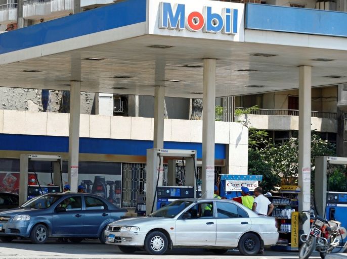 Vehicles are seen being filled up with fuel by employees at a Mobil petrol station in Cairo, Egypt June 29, 2017. REUTERS/Mohamed Abd El Ghany